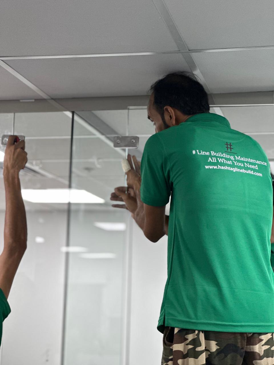 Technician fixing glass partition hardware